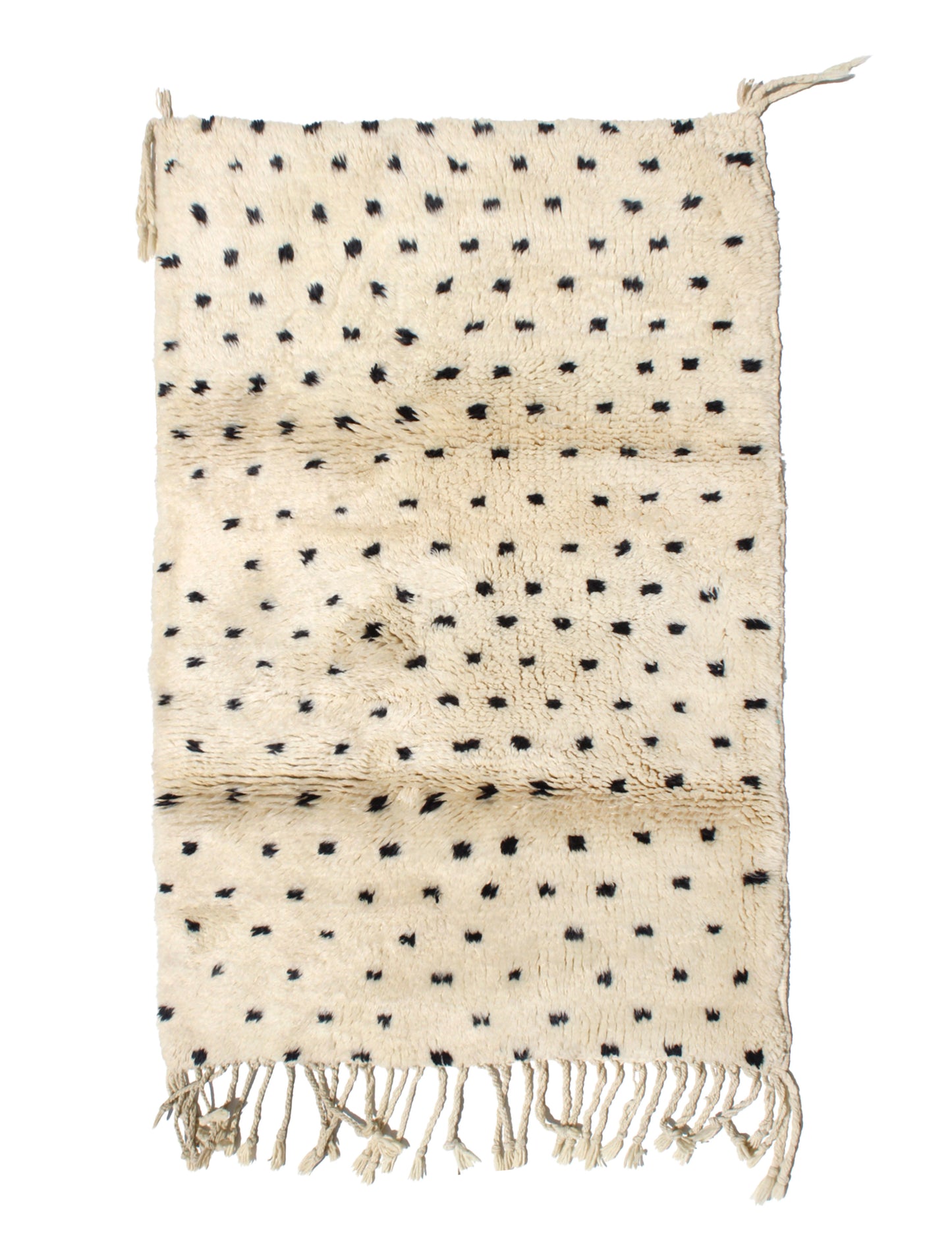 Hand-knotted cream Moroccan wool rug with scattered black polka dot tufts and natural ivory fringe, ideal for modern boho or nursery decor.

