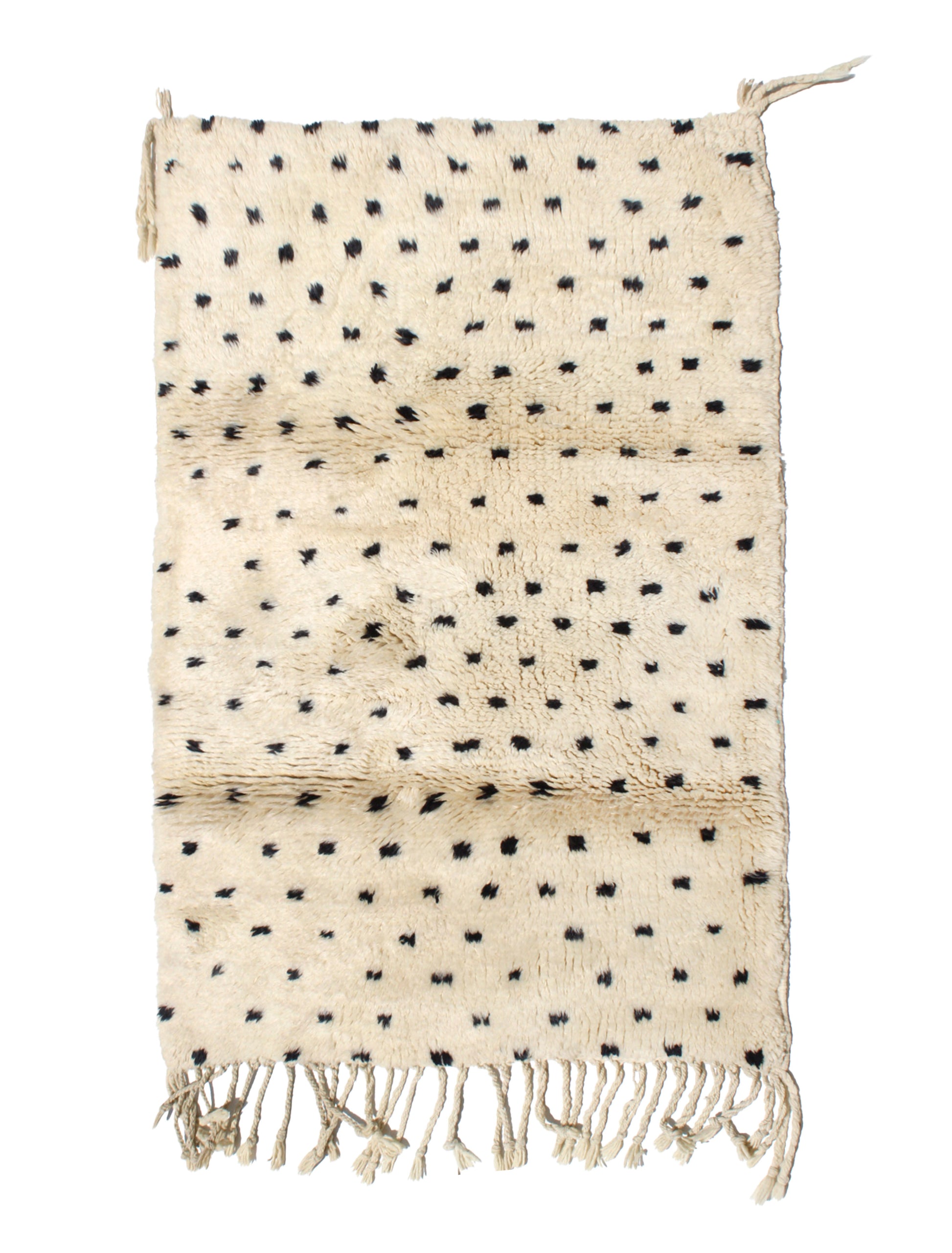 Hand-knotted cream Moroccan wool rug with scattered black polka dot tufts and natural ivory fringe, ideal for modern boho or nursery decor.

