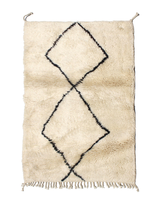Hand-knotted cream Moroccan wool rug featuring two large, intersecting black diamond motifs and natural cream fringe.

