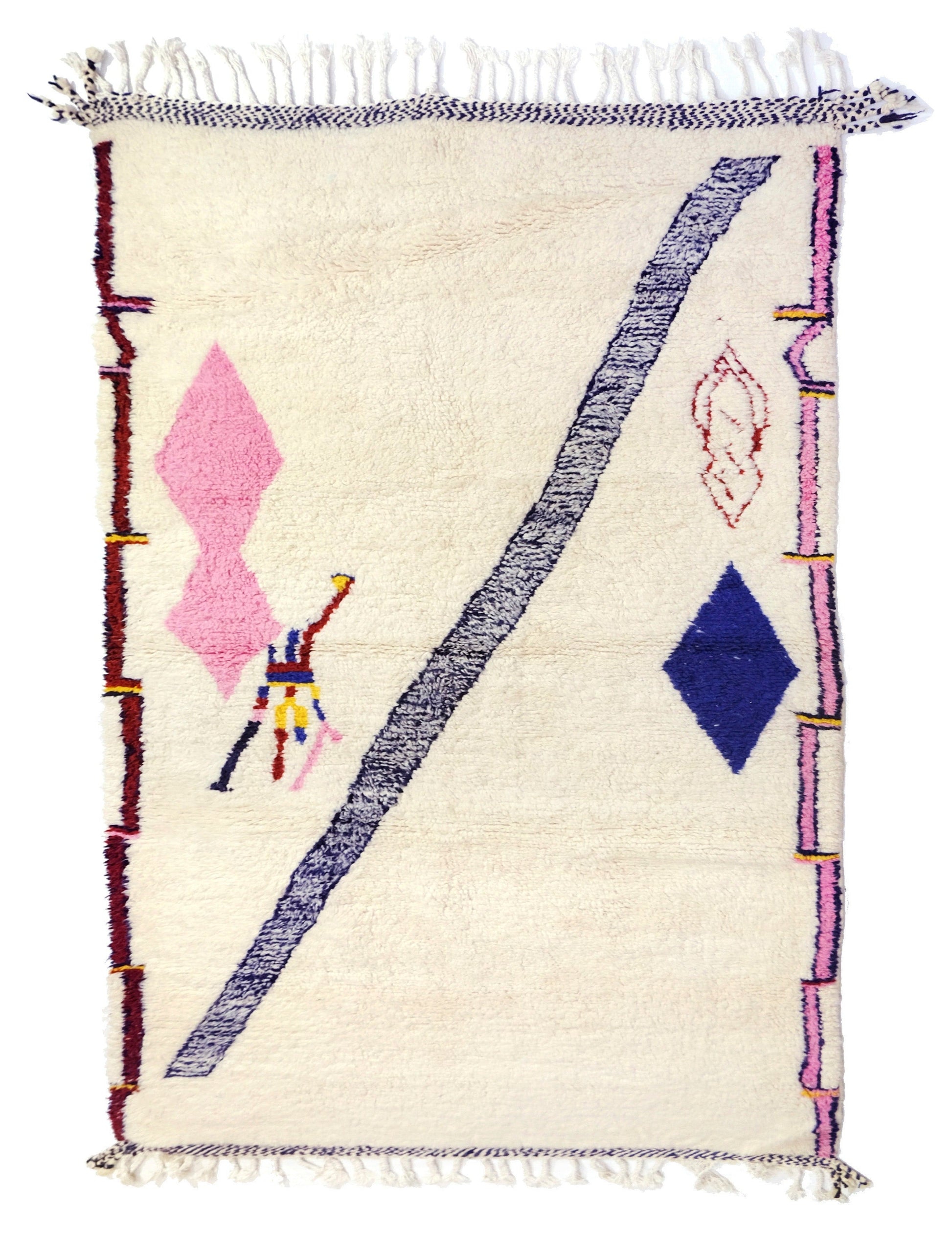Plush cream wool Moroccan Azilal rug featuring a whimsical abstract design with a charcoal diagonal stripe, pink and navy diamonds, a small stick-figure motif, colorful painterly borders, and top and bottom fringe, displayed on a white background.