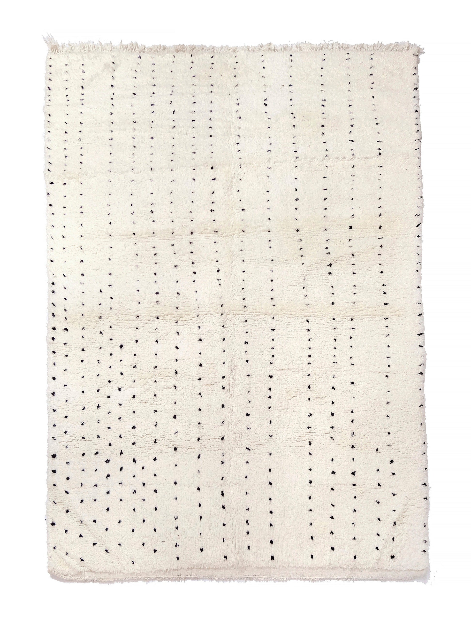 Plush cream wool rug featuring vertical dashed lines made of hand-knotted black dots and a short fringe along the top edge, displayed on a white background.

