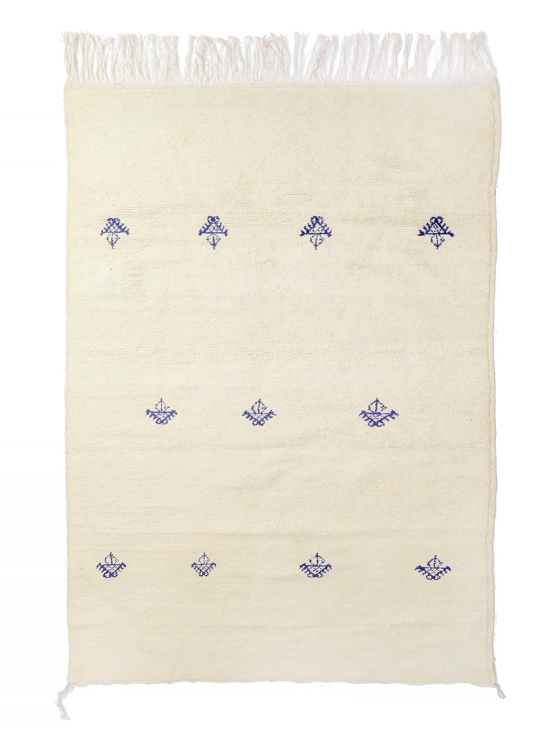 Soft cream hand-knotted wool rug featuring three sparse horizontal rows of deep indigo Berber tribal symbols, with knotted fringe on the top and bottom and small corner ties, displayed on a white background.