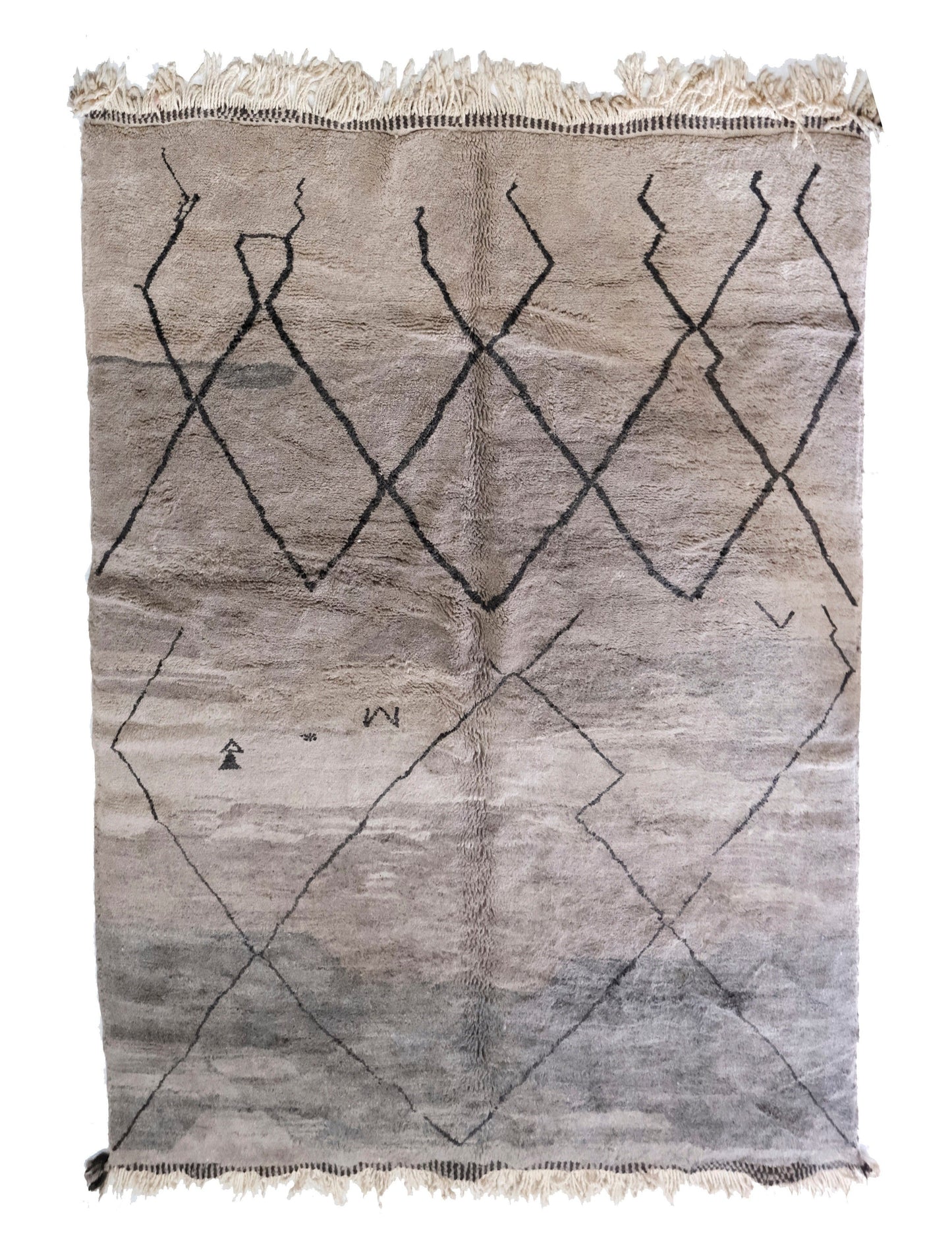 Muted grey plush handwoven Moroccan wool rug featuring a dark central joining seam, a "stepped" or broken black diamond lattice pattern, small scattered tribal motifs in the lower area, and cream fringe at the top and bottom, displayed on a white background.