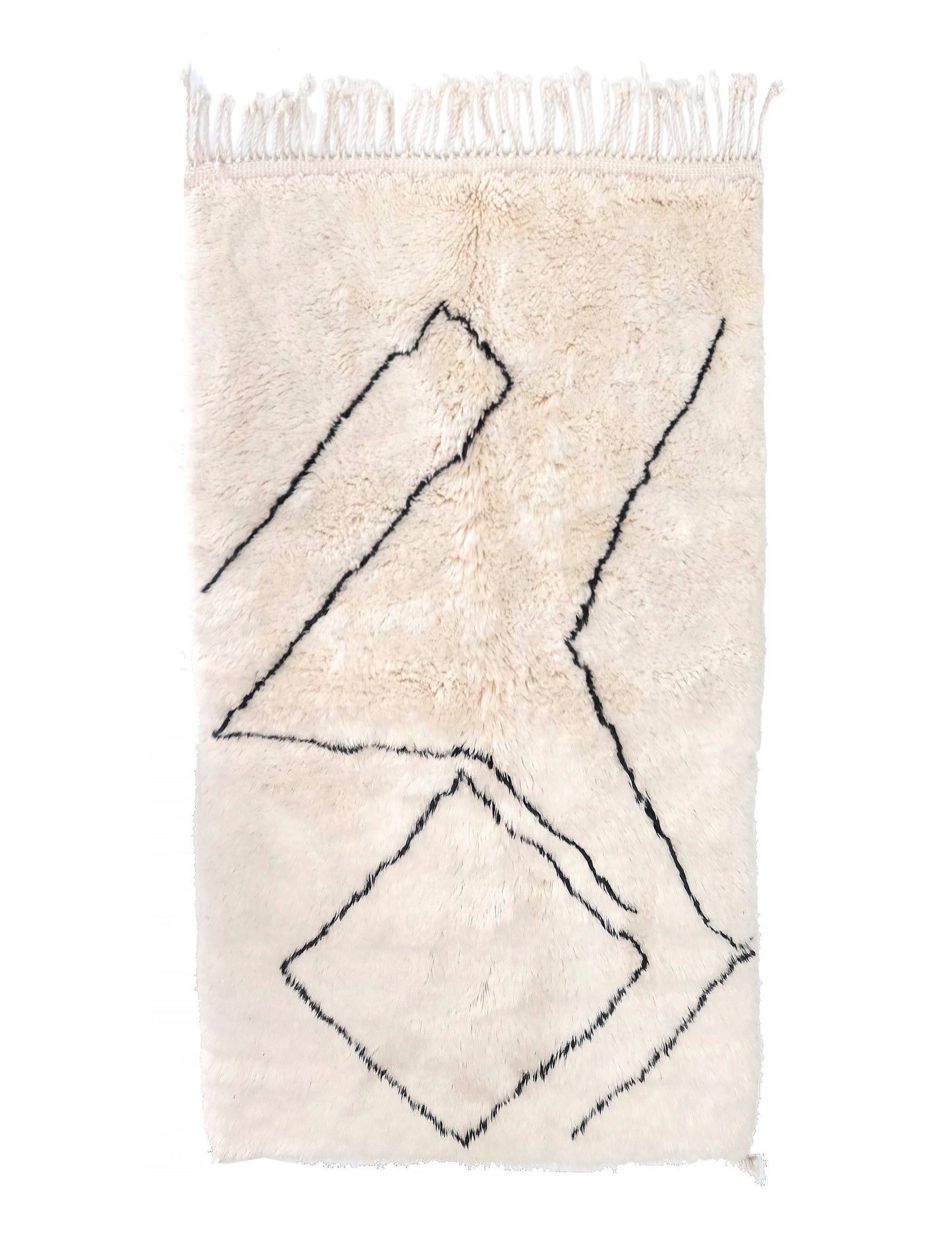 Plush cream wool rug featuring an abstract pattern of black hand-drawn angular lines and a broken diamond shape, with a knotted top fringe and a small bottom corner tie, displayed on a white background.