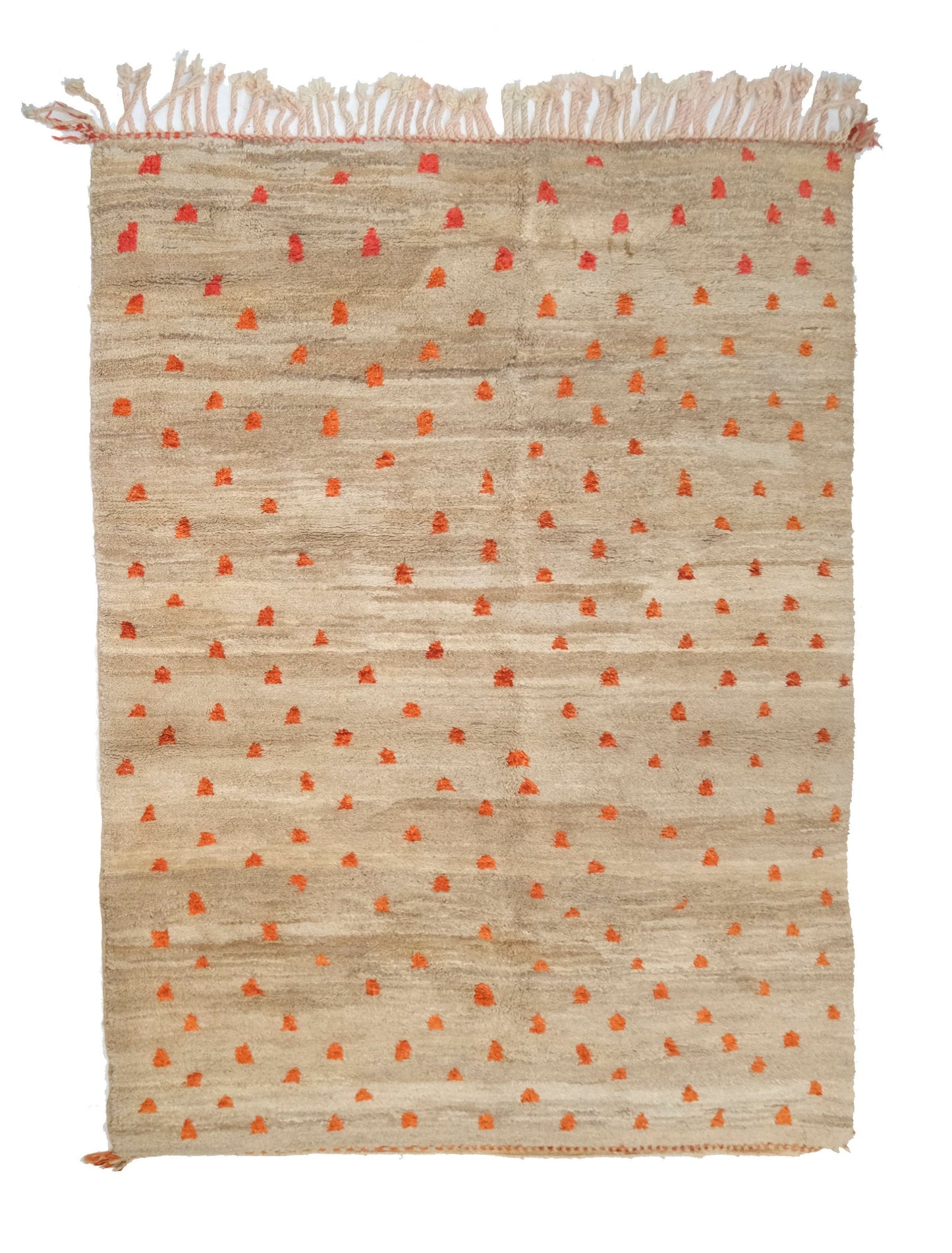 Plush hand-knotted taupe and camel wool rug featuring a subtle central seam and a scatter of vibrant orange and rust-colored primitive tribal symbols, with a twisted top fringe and small braided corner ties, displayed on a white background.