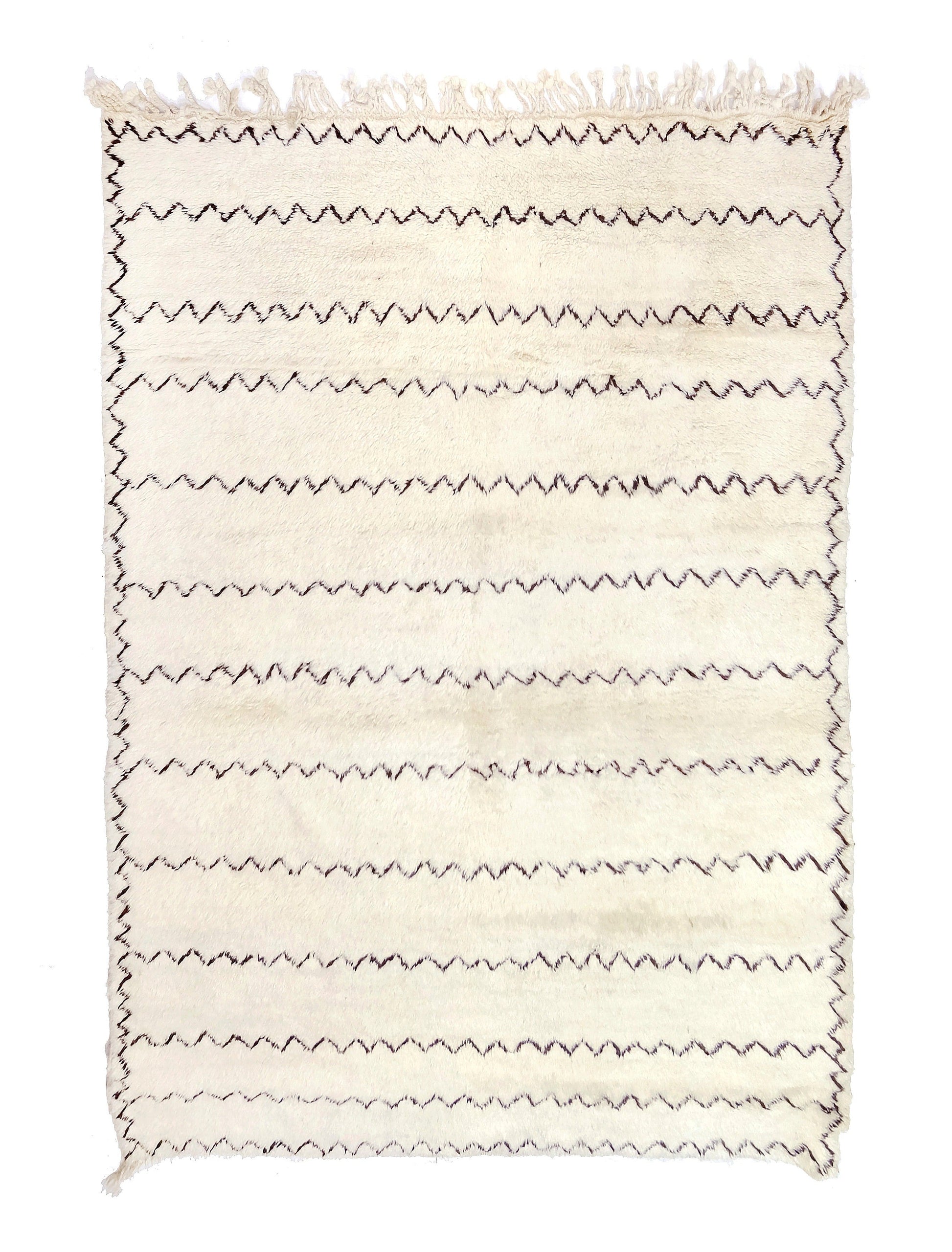 Plush cream handwoven Moroccan wool rug featuring several thin, wavy black horizontal zigzag lines and a loose black border, with a top fringe and a small bottom left corner tie, displayed on a white background.