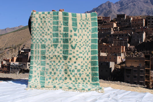 Beni Ourain rugs originate from the Atlas Mountains of Morocco and are characterized by their distinctive, neutral-toned, and geometric designs. These handwoven rugs often feature a plush pile and are made by the Berber tribes,  size is 215x160 cm