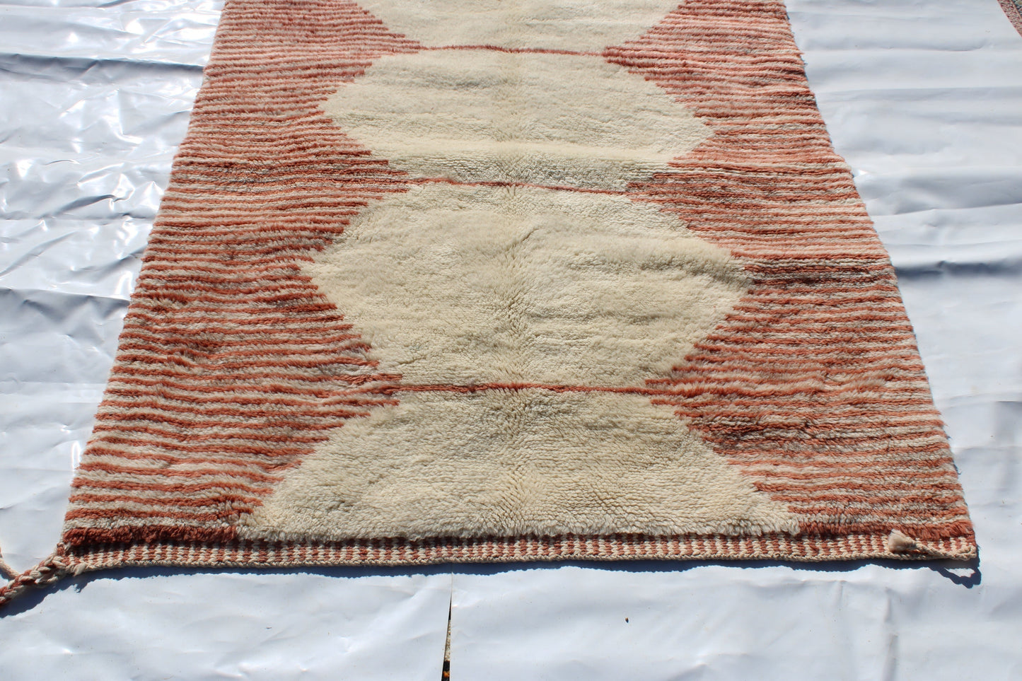 Beni Ourain rugs originate from the Atlas Mountains of Morocco and are characterized by their distinctive, neutral-toned, and geometric designs. These handwoven rugs often feature a plush pile and are made by the Berber tribes,  size is 255x150 cm